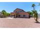 The spacious backyard has desert landscaping, a covered patio, and palm trees at 2213 N Ashbrook Cir, Mesa, AZ 85213