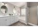 Bathroom featuring dual sinks, sleek white cabinetry, bathtub, and separate glass enclosed shower at 2213 N Ashbrook Cir, Mesa, AZ 85213