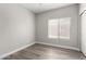 Empty bedroom with wood-look flooring and a bright window at 2213 N Ashbrook Cir, Mesa, AZ 85213