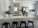 Bright kitchen with white cabinets, quartz countertops, stainless steel appliances and black bar stools at 2213 N Ashbrook Cir, Mesa, AZ 85213