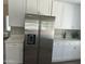 Spacious kitchen featuring stainless steel refrigerator, white cabinets, and quartz countertops at 2213 N Ashbrook Cir, Mesa, AZ 85213