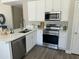 Well-lit kitchen with white cabinets, quartz countertops, and modern stainless steel appliances at 2213 N Ashbrook Cir, Mesa, AZ 85213