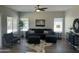 Cozy living room featuring modern decor, large sofa, ceiling fan, and ample natural light at 2213 N Ashbrook Cir, Mesa, AZ 85213