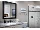 Modern bathroom features a granite countertop, dark fixtures, and a glass-enclosed shower for a luxurious experience at 26885 N 104Th Pl, Scottsdale, AZ 85262