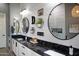 A sleek bathroom with granite counters, dual sinks, and decorative hanging mirrors at 26885 N 104Th Pl, Scottsdale, AZ 85262