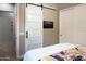 Cozy bedroom features a sliding barn door closet, complementing the floral bedding and creating a modern aesthetic at 26885 N 104Th Pl, Scottsdale, AZ 85262