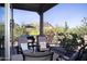 Covered patio with comfortable seating offers a serene outdoor living space with views of desert landscaping and mountains at 26885 N 104Th Pl, Scottsdale, AZ 85262