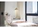 Close-up of main bedroom with a cozy bed, accent lighting, and a large window at 312 E Windsor Ave # 6, Phoenix, AZ 85004