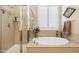 Elegant bathroom featuring a soaking tub, walk-in shower, and natural light at 33305 N 26Th Ave, Phoenix, AZ 85085