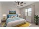 Cozy bedroom features a comfortable bed with blue accents, a ceiling fan, and a bright window at 3704 E Haflinger Rd, San Tan Valley, AZ 85140