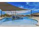 Community pool with splash pad and comfortable lounge seating with shaded umbrellas at 3704 E Haflinger Rd, San Tan Valley, AZ 85140