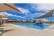 Large community pool with splash pad and lounge seating with shaded umbrellas at 3704 E Haflinger Rd, San Tan Valley, AZ 85140