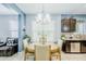Dining area with a round wooden table, upholstered chairs, chandelier, and view into the kitchen at 3947 W Maggie Dr, San Tan Valley, AZ 85144