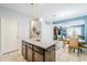 Kitchen island with granite countertops and wood cabinets is adjacent to dining area in an open floorplan at 3947 W Maggie Dr, San Tan Valley, AZ 85144