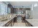 Well-lit kitchen with stainless steel appliances, tile backsplash, granite countertops, and dark wood cabinets at 3947 W Maggie Dr, San Tan Valley, AZ 85144