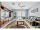 Cozy living room with plush leather sofa, wood entertainment center, ceiling fan, and sliding glass doors to patio at 3947 W Maggie Dr, San Tan Valley, AZ 85144