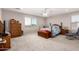 Neutral bedroom with a ceiling fan, window, and wood furniture with a chest in the center at 40141 W James Ln, Maricopa, AZ 85138