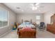 Cozy bedroom features a ceiling fan, window, and rocking chair for relaxation at 40141 W James Ln, Maricopa, AZ 85138