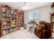 Bedroom with a large bookcase, an armchair, and an electronic keyboard by the window at 40141 W James Ln, Maricopa, AZ 85138