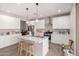 Bright kitchen with white cabinets, a center island, pendant lighting, and modern appliances at 40141 W James Ln, Maricopa, AZ 85138