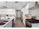 Contemporary kitchen features stainless steel appliances, white cabinets, and an island with a sink at 40141 W James Ln, Maricopa, AZ 85138