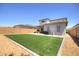 Spacious backyard with artificial grass, gravel accents, and a covered patio, perfect for outdoor living at 40927 W Sunland Dr, Maricopa, AZ 85138