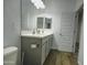 Neutral bathroom featuring a gray double vanity, modern fixtures, and stylish wood-look tile flooring at 40927 W Sunland Dr, Maricopa, AZ 85138