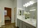 Elegant bathroom with double sink vanity, stylish mirrors, and modern lighting at 40927 W Sunland Dr, Maricopa, AZ 85138