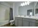 Bathroom with double vanity, gray cabinets, and a shower-tub combo at 40927 W Sunland Dr, Maricopa, AZ 85138