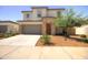 Beautiful two-story home featuring a stone facade, well-manicured landscaping, and a wide driveway with a two-car garage at 40927 W Sunland Dr, Maricopa, AZ 85138