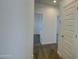 Hallway leading to bedrooms, featuring neutral paint and carpet at 40927 W Sunland Dr, Maricopa, AZ 85138