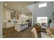 Modern kitchen with white cabinets, stainless steel appliances, an island with seating, and seamless access to the living area at 40927 W Sunland Dr, Maricopa, AZ 85138