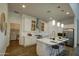 Gourmet kitchen with white cabinets, stainless steel appliances, island with bar stools, and a nearby laundry room at 40927 W Sunland Dr, Maricopa, AZ 85138