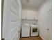 Functional laundry room with a washer, dryer, white cabinets, and a folding countertop, offering convenience and organization at 40927 W Sunland Dr, Maricopa, AZ 85138