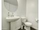 Simple powder room with pedestal sink, round mirror, and modern fixtures at 40927 W Sunland Dr, Maricopa, AZ 85138
