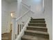 Staircase featuring carpeted steps, white railings and an adjacent half bath at 40927 W Sunland Dr, Maricopa, AZ 85138