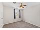 Carpeted bedroom with ceiling fan, window, and neutral color scheme at 4154 W Morten Ave, Phoenix, AZ 85051