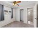 Neutral bedroom featuring a ceiling fan, window with blinds, and closet with sliding doors at 4154 W Morten Ave, Phoenix, AZ 85051