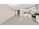 Modern kitchen featuring white cabinetry, stainless steel appliances, open to dining area with fireplace enhancing the living space at 4154 W Morten Ave, Phoenix, AZ 85051