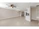 Bright living room with tile flooring leads to a kitchen with stainless steel appliances, creating a seamless open-concept living space at 4154 W Morten Ave, Phoenix, AZ 85051