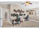 A bedroom with white walls, carpet floors, a ceiling fan, two workspaces, and a hallway entry at 4402 E Barwick Dr, Cave Creek, AZ 85331