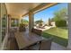 Covered patio with comfortable outdoor seating that overlooks the green backyard and pool at 4402 E Barwick Dr, Cave Creek, AZ 85331