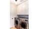 Bright laundry room with front loading washer and dryer and white cabinetry at 4402 E Barwick Dr, Cave Creek, AZ 85331