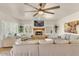 Cozy living room boasts a decorative fireplace, ceiling fan, neutral palette and shuttered windows at 4402 E Barwick Dr, Cave Creek, AZ 85331