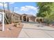 A tan-colored house boasting mature xeriscaping, a three-car garage, and inviting curb appeal in a desert landscape at 4667 E County Down Dr, Chandler, AZ 85249