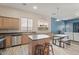 Kitchen island with sink and seating, natural cabinets, and a view of the living space beyond at 4667 E County Down Dr, Chandler, AZ 85249