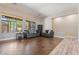 Sunlit living room featuring wood floors, neutral walls, large windows, and comfortable gray sofas at 4667 E County Down Dr, Chandler, AZ 85249