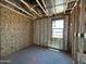 Unfinished bedroom with exposed framing and insulation shows window placement and wiring at 46868 W Coe St, Maricopa, AZ 85139