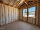 Unfinished bedroom with exposed framing and insulation shows space and window placement at 46868 W Coe St, Maricopa, AZ 85139