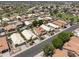 An aerial view of a residential neighborhood with many tile roofed homes and green trees at 5211 W Wikieup Ln, Glendale, AZ 85308